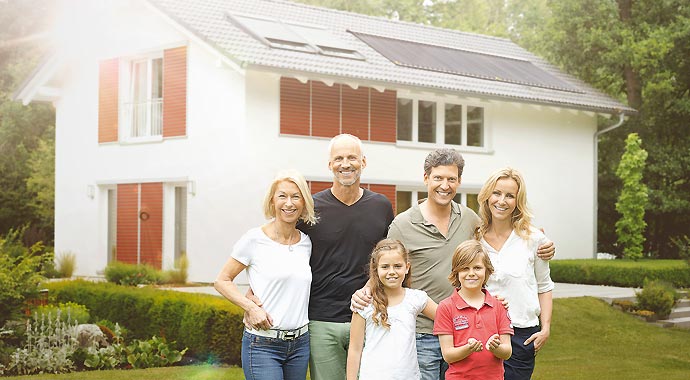 Familie vor Haus mit einer Solaranlage von Paradigma Familie vor Haus mit einer Solaranlage von Paradigma
