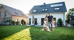 Baufamilie vor ihrem neuen EigenheimBaufamilie vor ihrem neuen Eigenheim