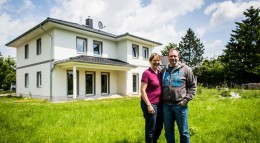 Bauen mit Bauträger Bauherren vor ihrem neu errichteten Eigenheim