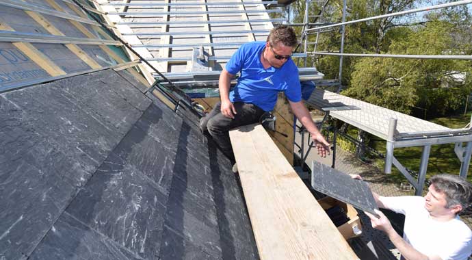Dachdecker arbeiten an einem Schieferdach von Rathscheck