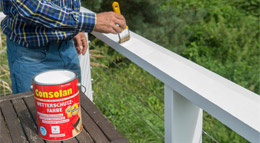 Consolan Wetterschutzfarbe wird auf ein Holzgeländer aufgetragen