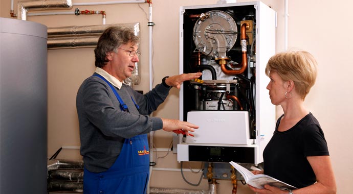 SHK-Handwerker erklärt Kundin eine Heizung